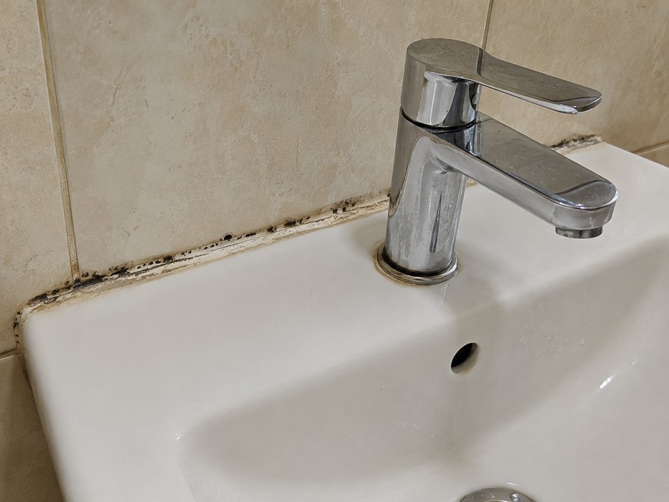 Waschbecken mit alter, verschmutzter Silikonfuge